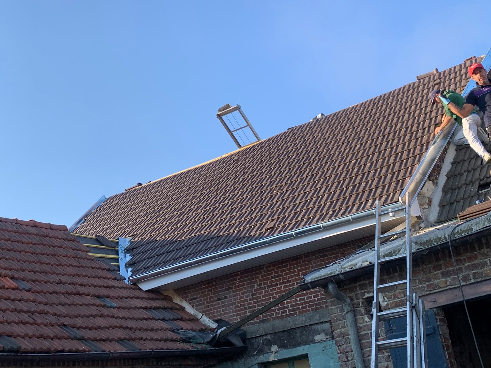 Couvreur travaillant au faîtage d'une toiture neuve